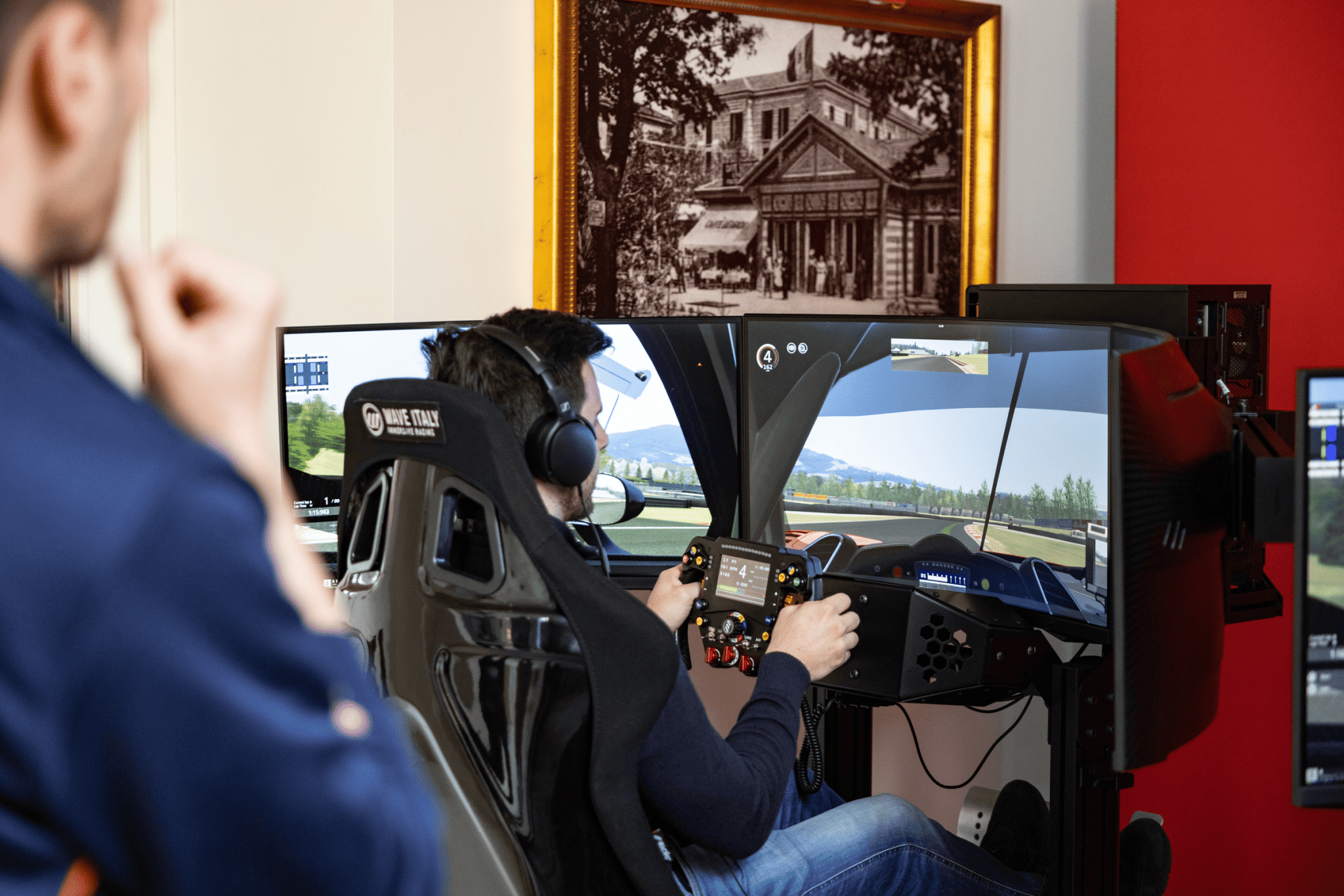 Immagine che ritrae un pilota che guida un simulatore di guida professionale Wave Italy durante un evento in hotel. Image showing a driver operating a Wave Italy professional driving simulator during a hotel event.